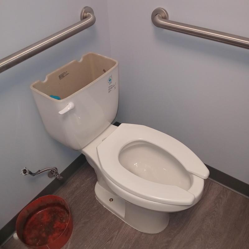 Toilet tank with open lid in commercial restroom Toilet tank with open lid in commercial restroom