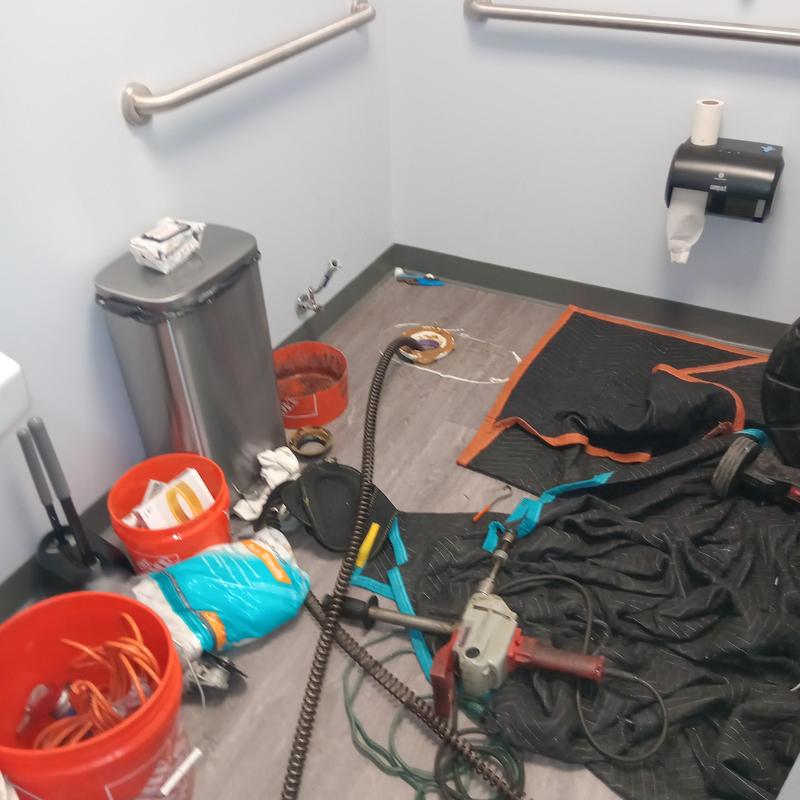 Main line plumbing tools and materials in commercial restroom Main line plumbing tools and materials in commercial restroom