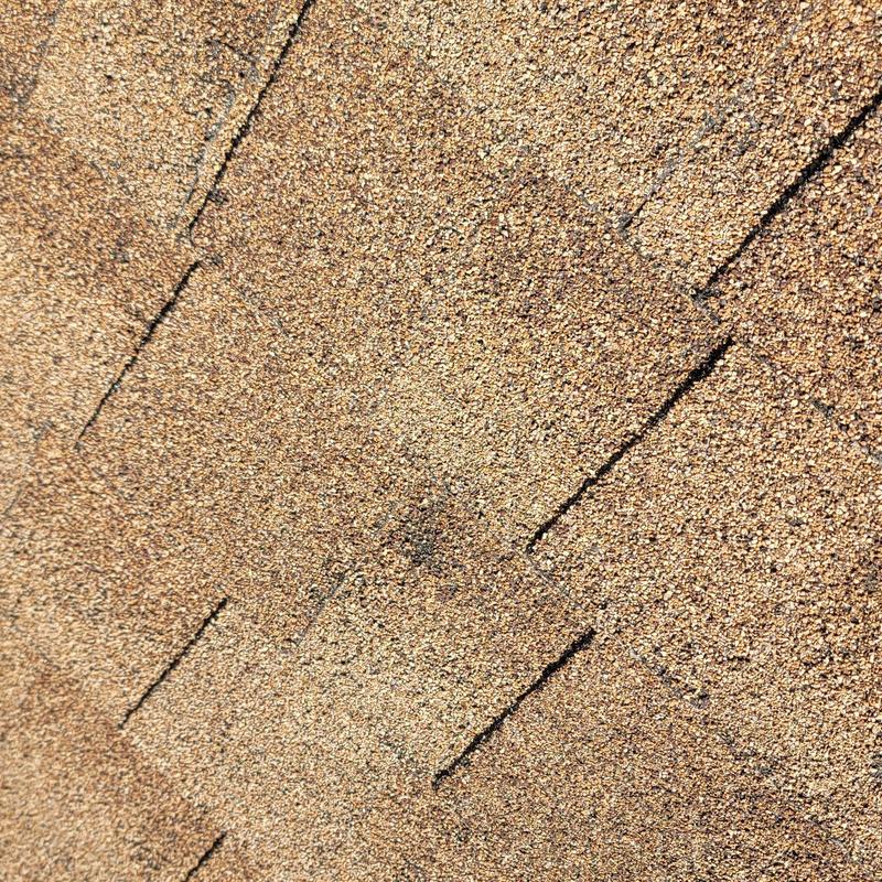 Asphalt roof shingles with hail damage close-up