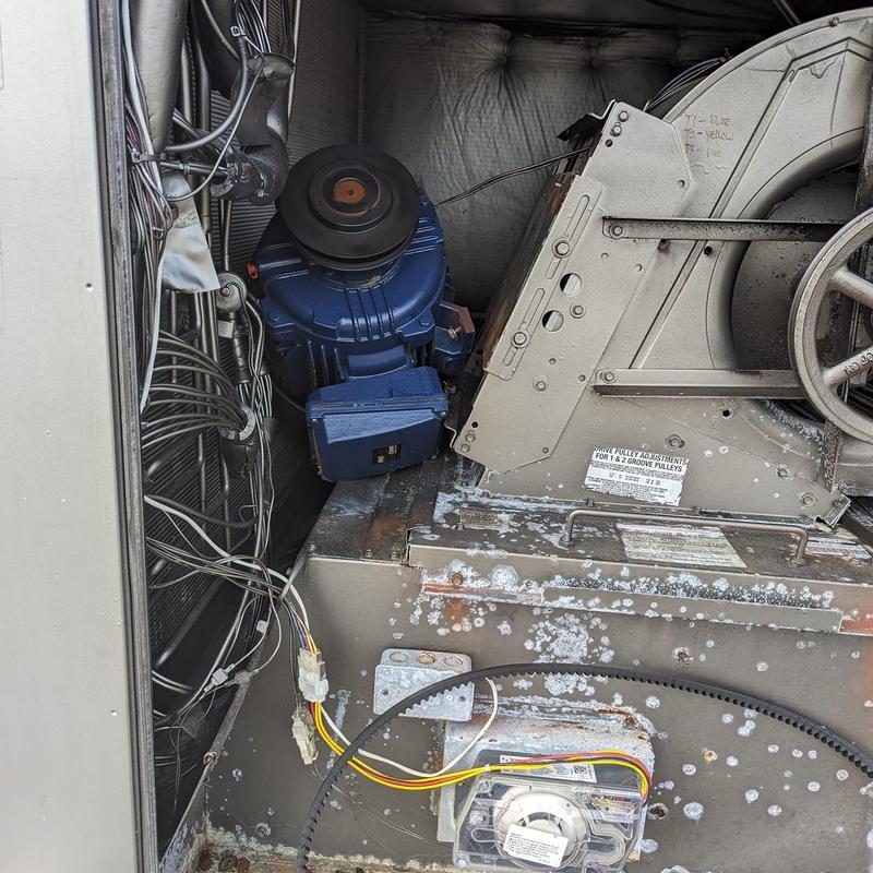 AC motor and pulley belt inside commercial HVAC unit AC motor and pulley belt inside commercial HVAC unit