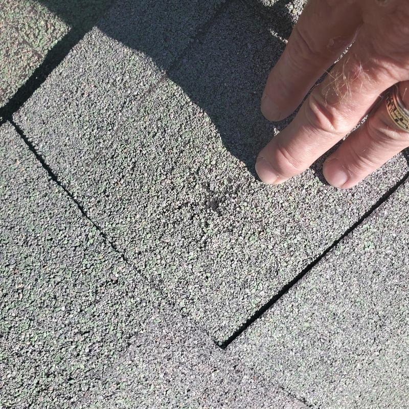 Asphalt roof shingles with hail damage closeup