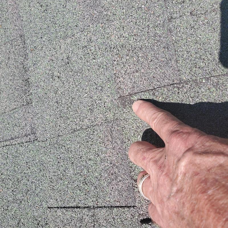 Asphalt roof shingles with hail damage close-up