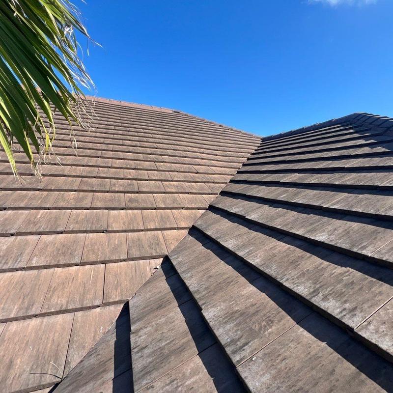 Concrete tile roof on residential home under clear sky