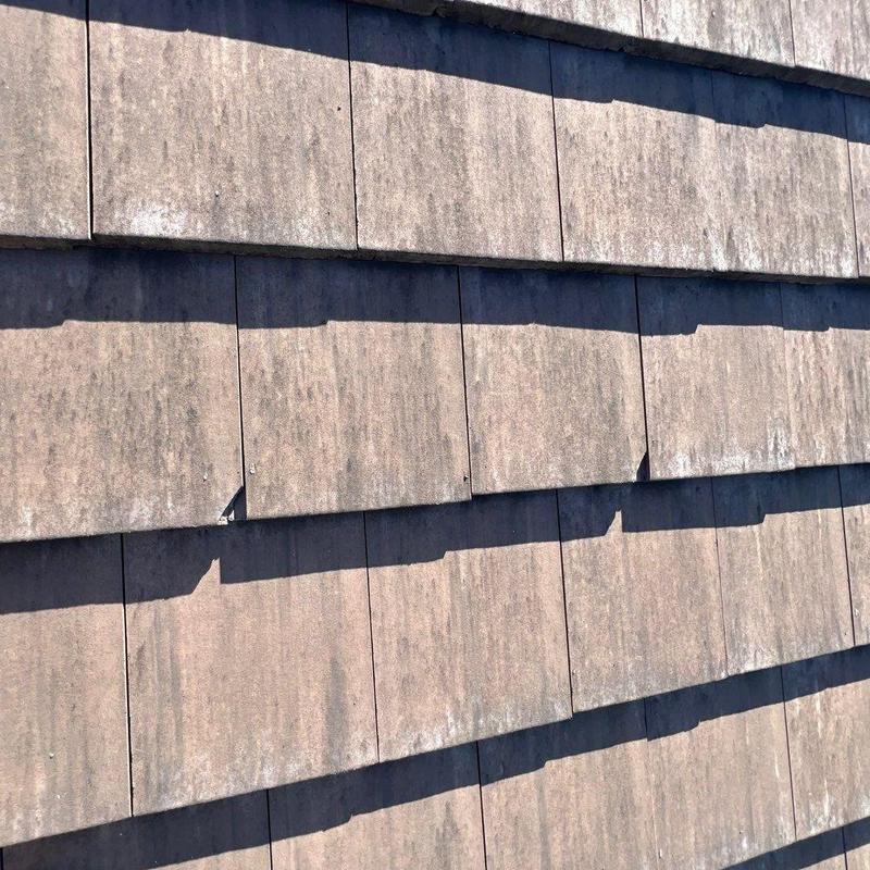 Concrete tile roof surface showing wear and minor damage