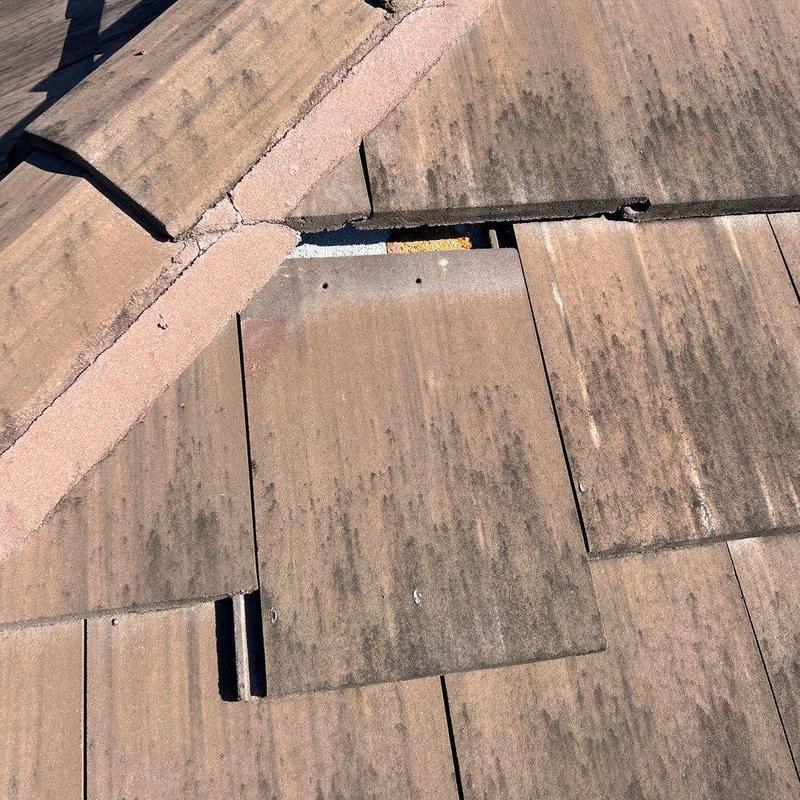 Concrete roof tiles with visible damage and gaps