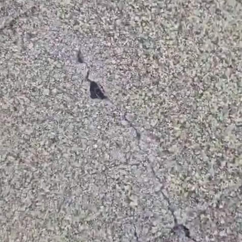 Shingle roof close-up with crack and hole damage
