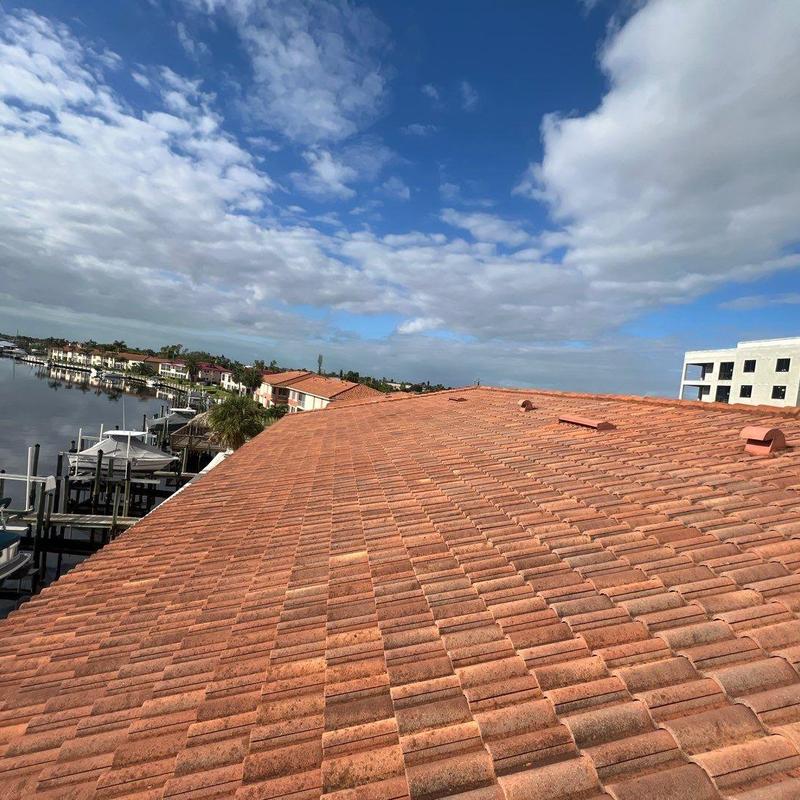 Concrete tile roof with vent pipes under cloudy sky