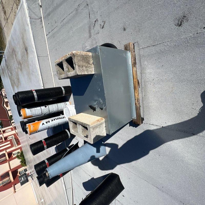 Modified bitumen roofing rolls and ventilation unit on flat roof