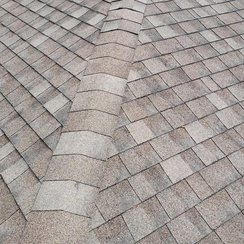 Shingle roof with replaced ridge cap shingles