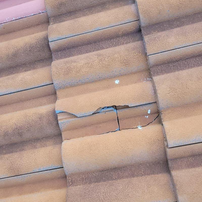 Concrete tile with cracks and damage on roof