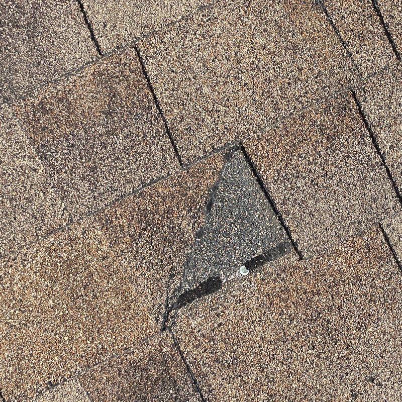 Asphalt shingle with minor damage and patched area