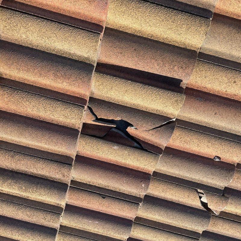 Concrete tile roof with visible cracks and damage