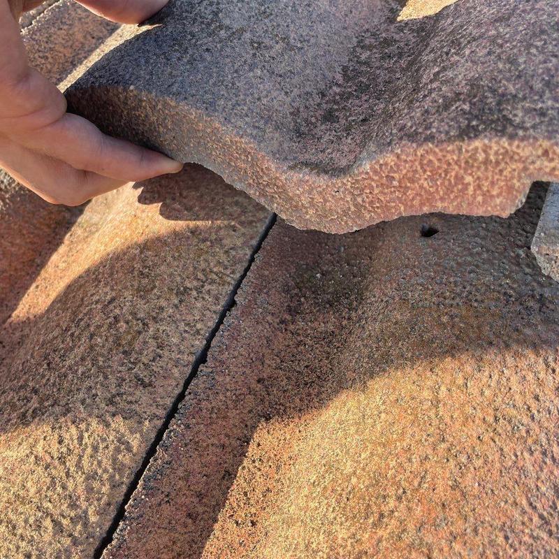 Concrete tile roof with broken tile close-up