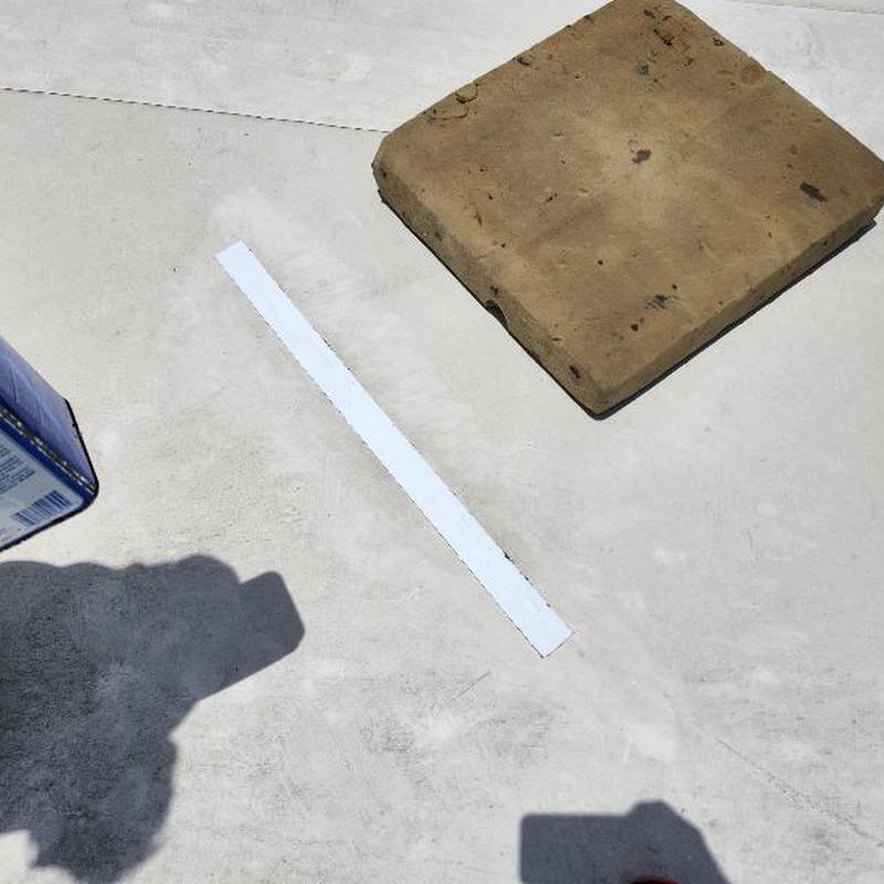 TPO roofing membrane with white patch and brick weight