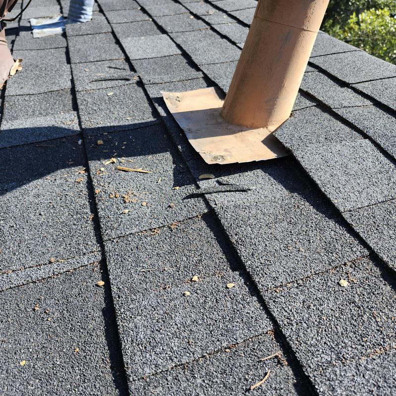 Plumbing vent pipe with flashing on roof shingles