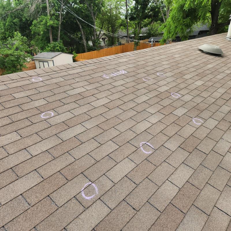 Roof shingles with hail damage marks on surface Roof shingles with hail damage marks on surface