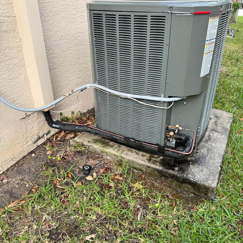 Central air conditioner unit with insulated refrigerant lines outdoors