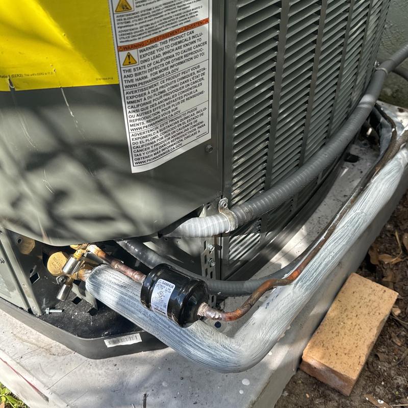 HVAC outdoor condenser unit with insulated refrigerant line