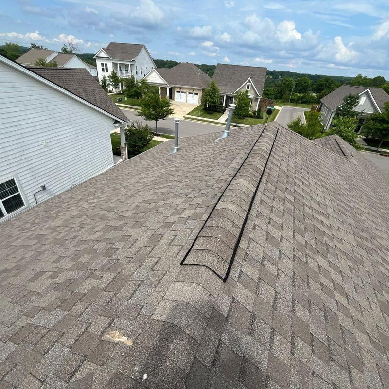 Roof shingles with hail and vent damage on residential roof