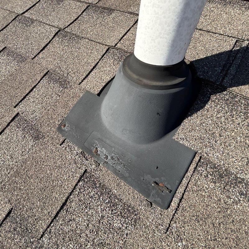 Roof vent flashing with hail damage and missing shingles