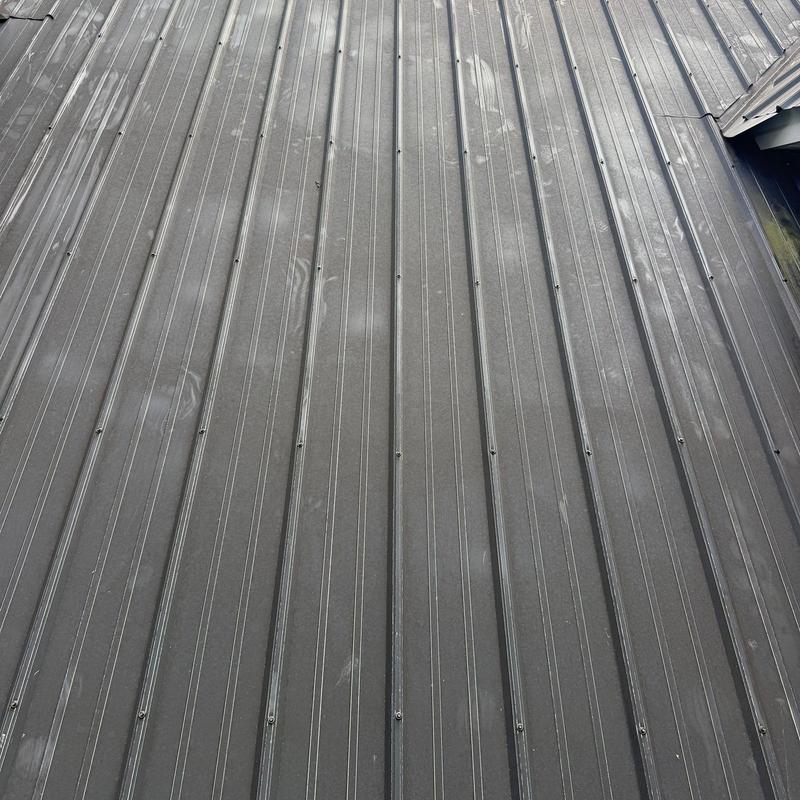 Metal roof panels with hail damage dents visible