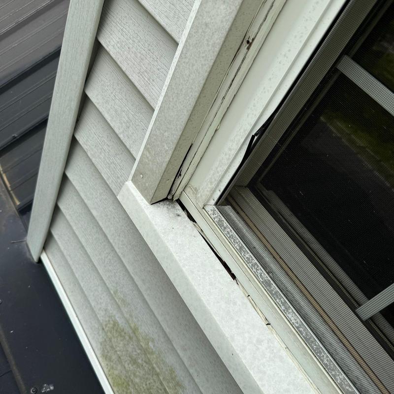 Window flashing with gaps and wear on siding trim