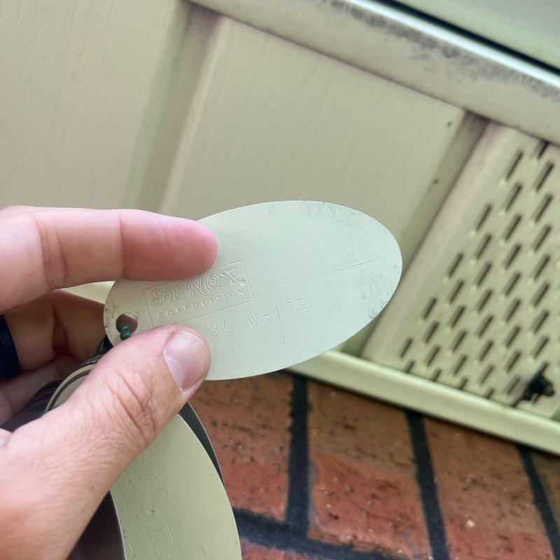 Ventilation soffit panel color sample near brick exterior