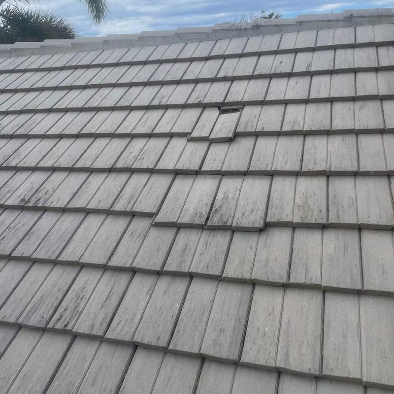 Concrete tile roof with damaged and lifted tiles