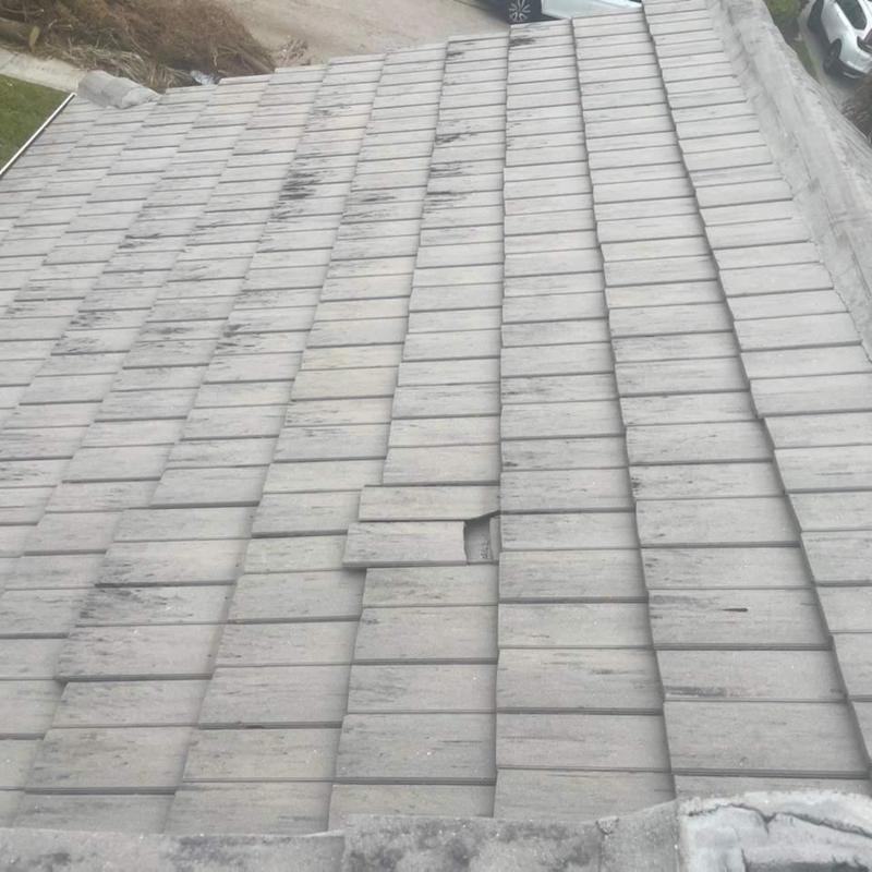 Concrete tile roof with damaged and misaligned tiles