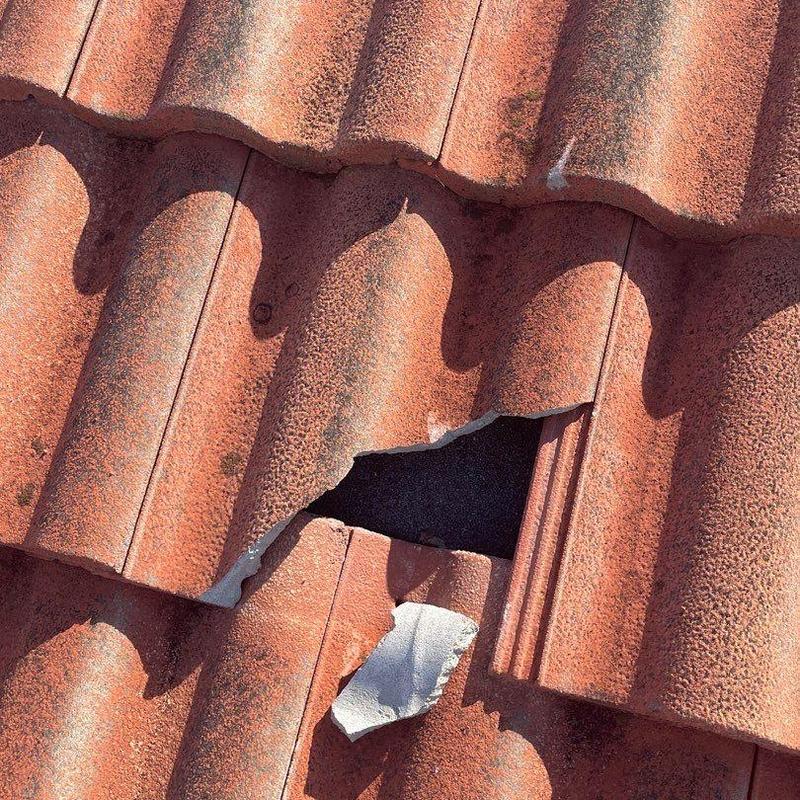 Concrete tile with broken section on roof surface