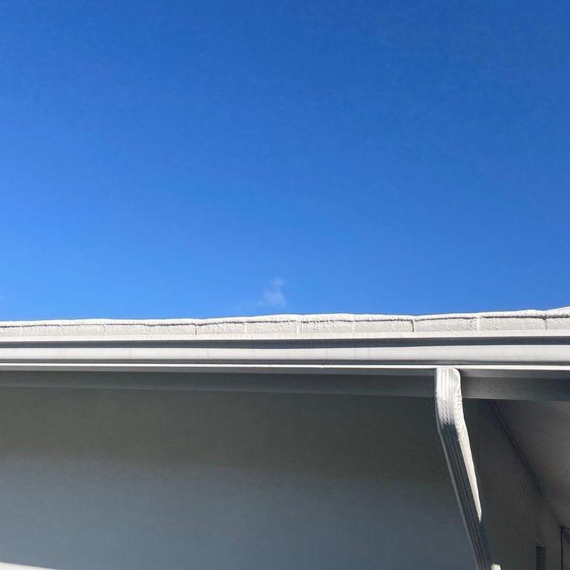 Vinyl gutter with visible bends and sagging under clear sky