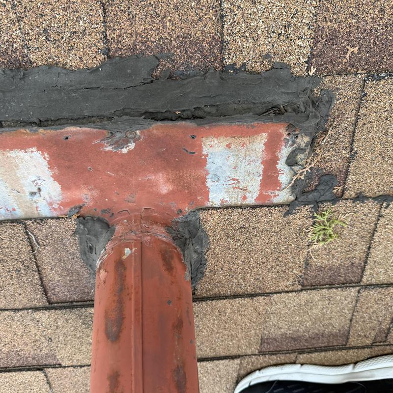 Metal roof pipe flashing with sealant on shingle roof