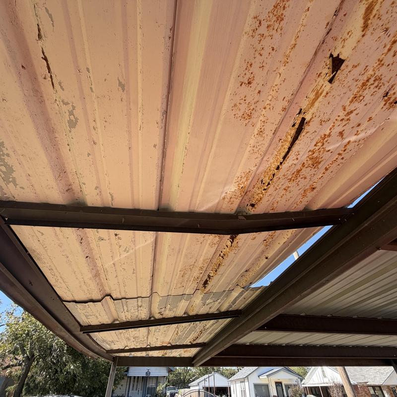 Metal carport ceiling with rust and damage