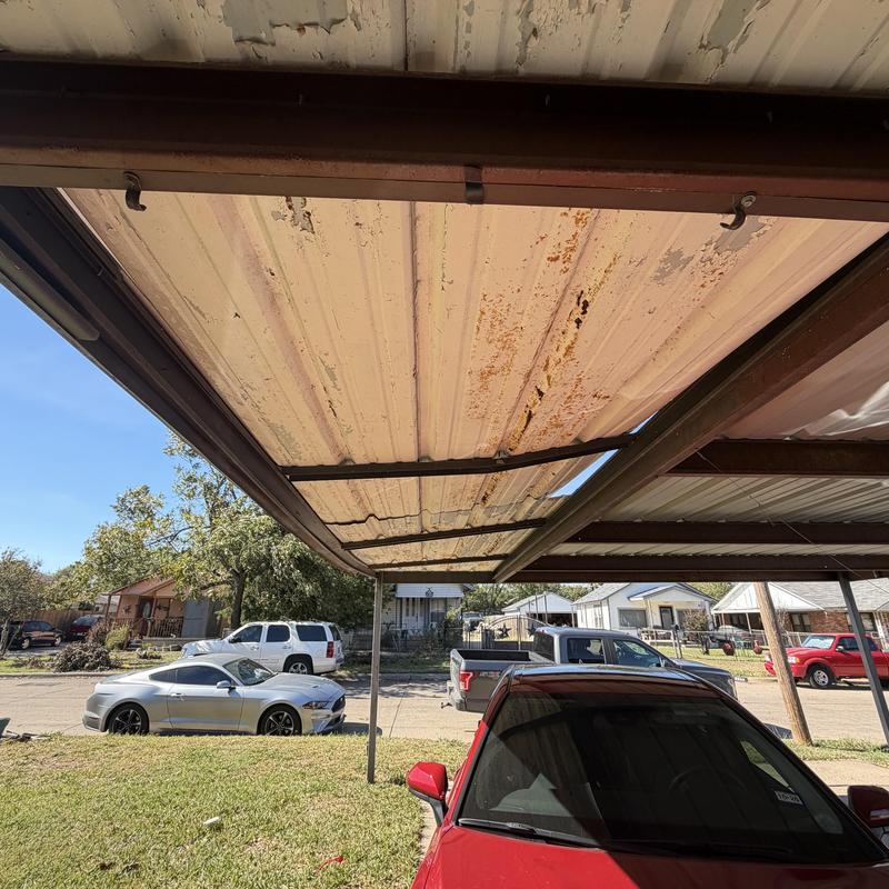Metal carport panels rusted and bent under storm damage