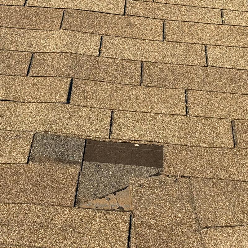 Asphalt roofing shingles with visible damage and wear
