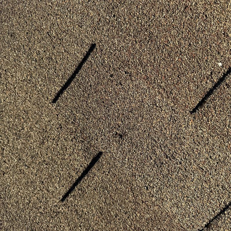 Asphalt shingle roof with visible hail damage dents