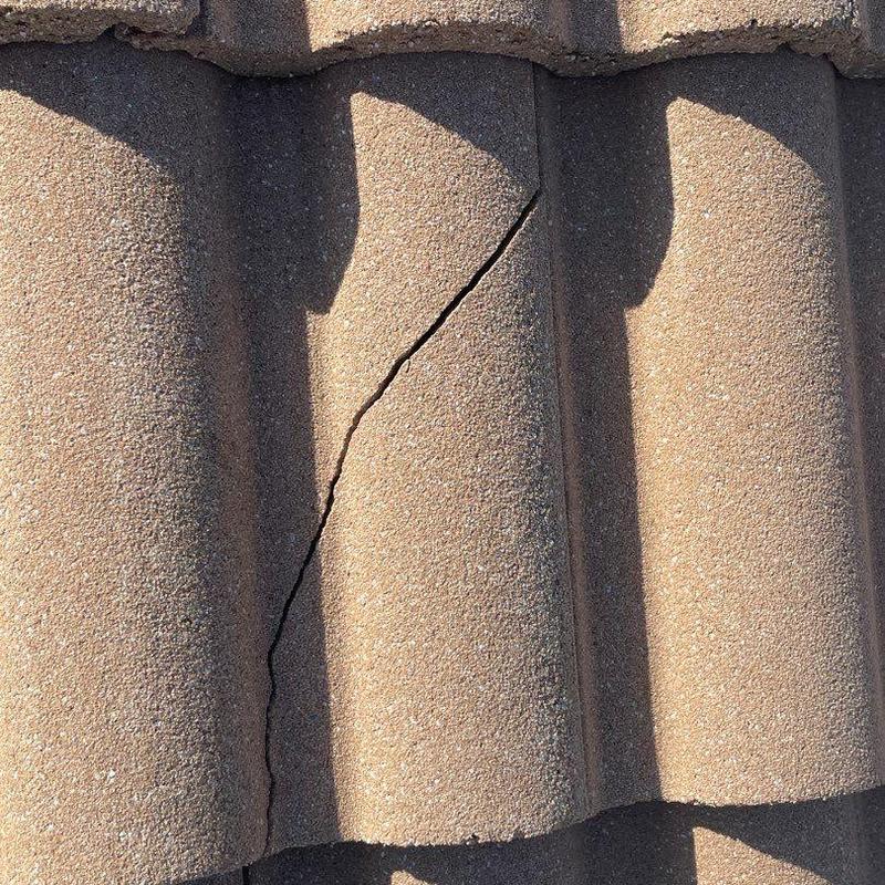 Concrete tile with visible crack on roof surface