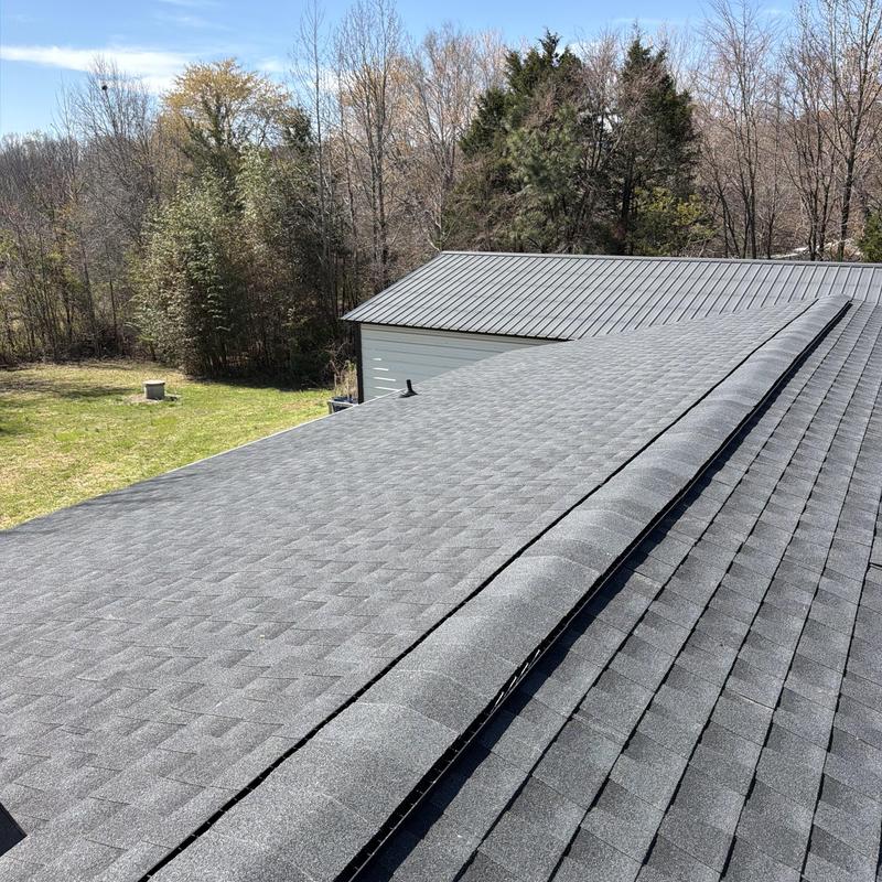 Asphalt shingle roof with new ridge cap and siding building