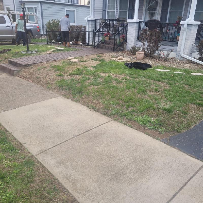 Brick walkway installation beside residential porch steps