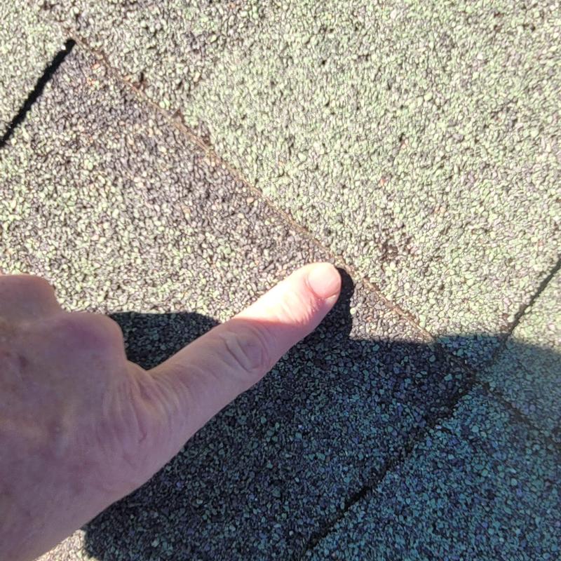 Asphalt roof shingles with hail damage close-up