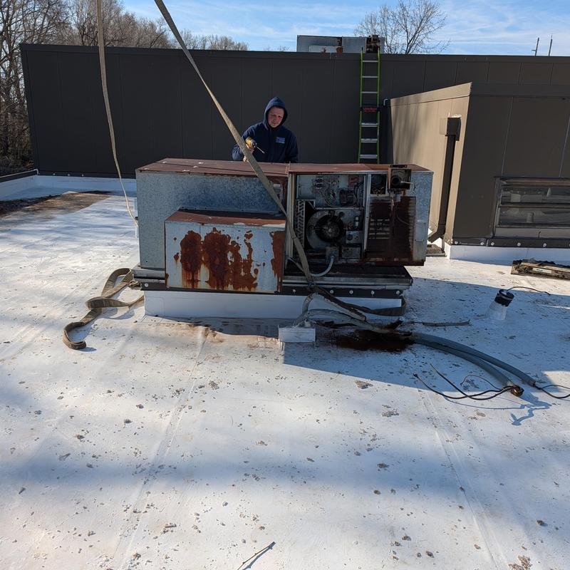 Rusted rooftop AC unit removal on white PVC roof