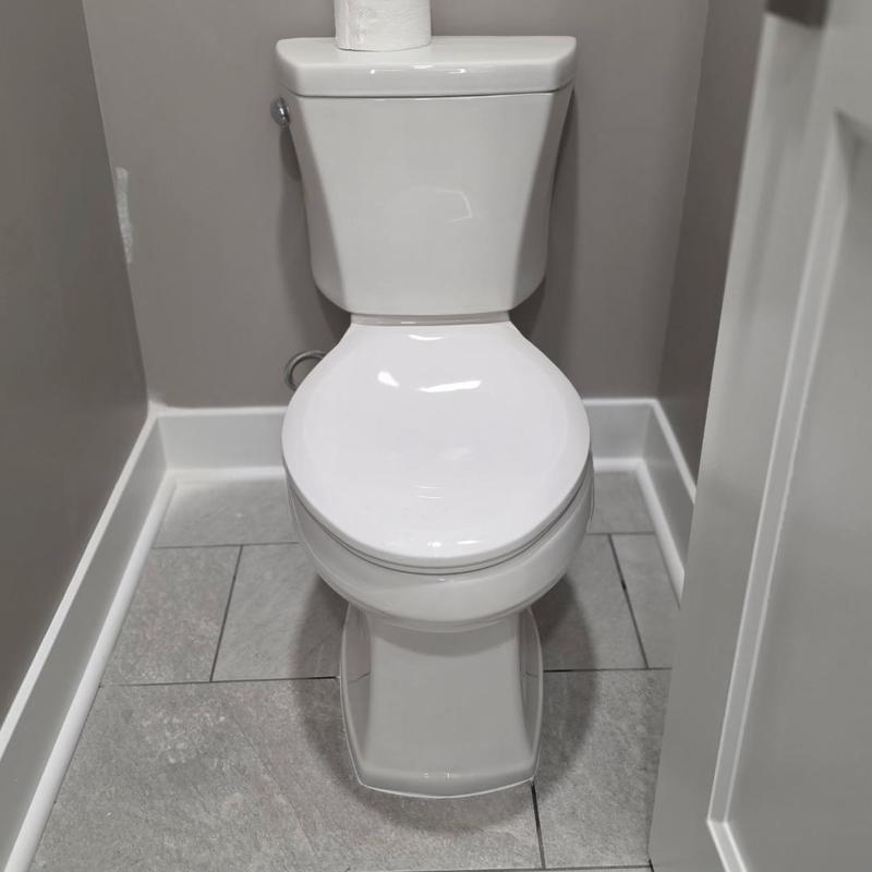 Toilet installation in small bathroom with gray tile