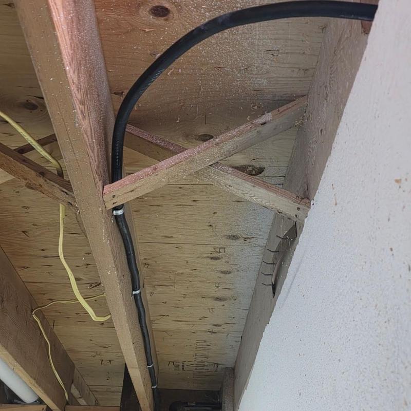 Gas line installation with black pipe under ceiling beams