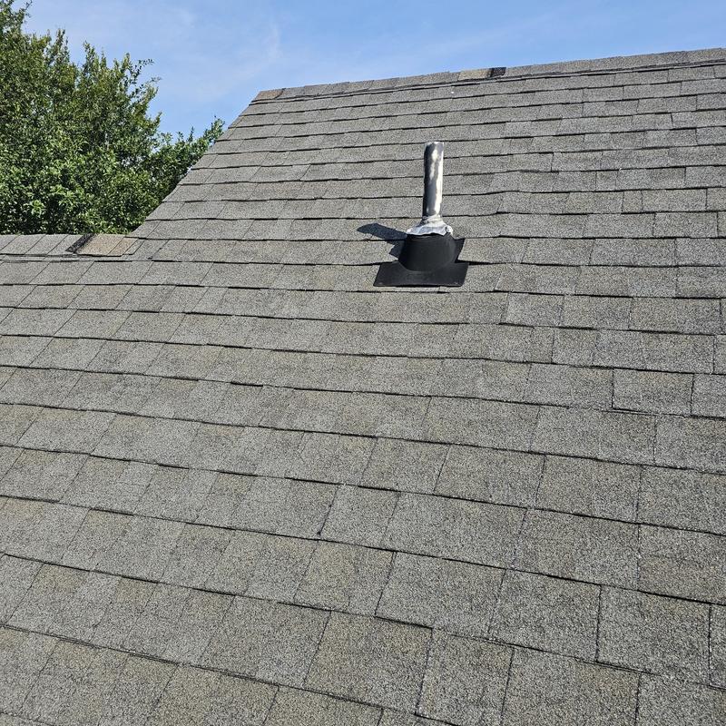 Asphalt shingle roof with vent pipe and hail damage