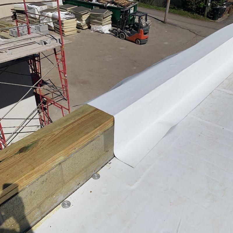 TPO roofing membrane installation on commercial roof edge