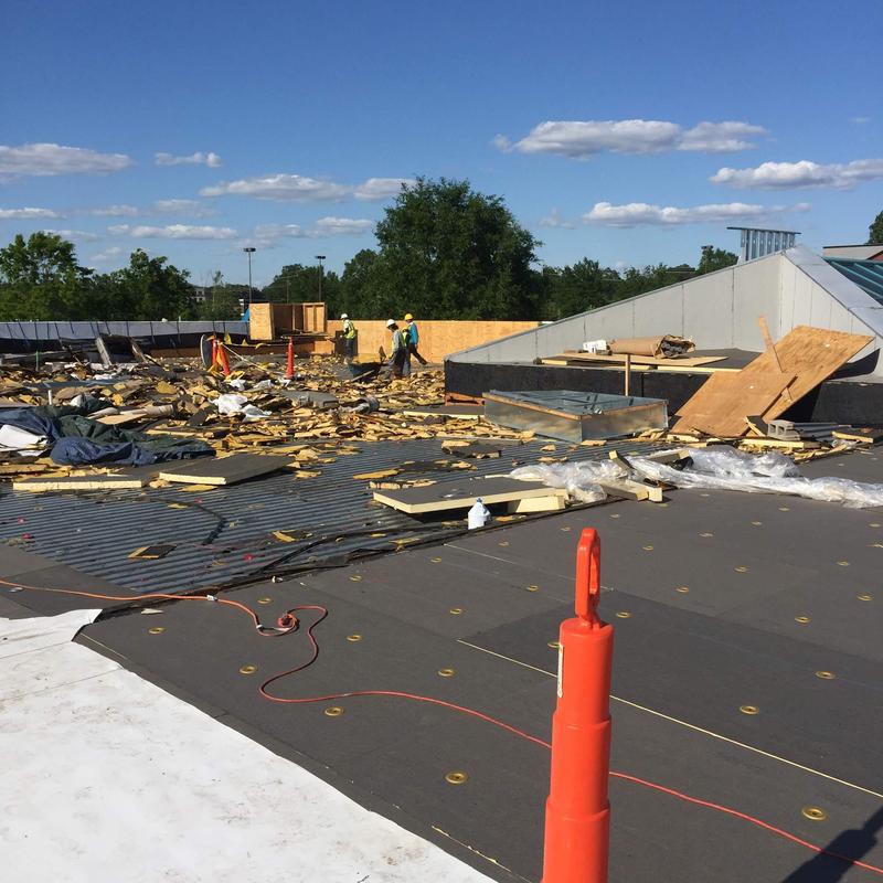 Single ply roofing installation with debris and workers