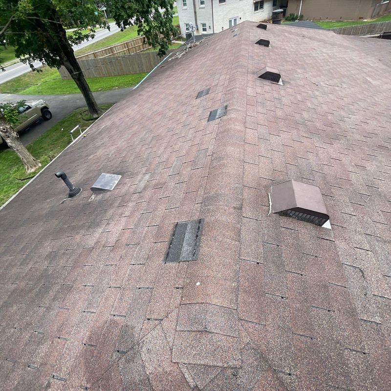 Asphalt shingle roof showing hail damage and aging signs