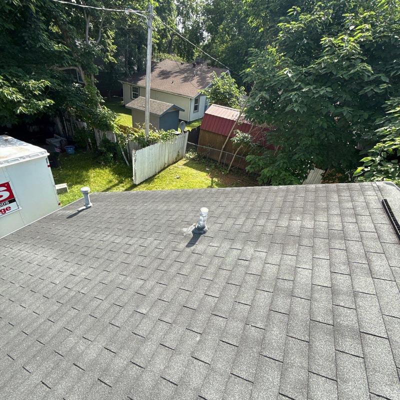 Roof shingles with vent pipes and surrounding yard