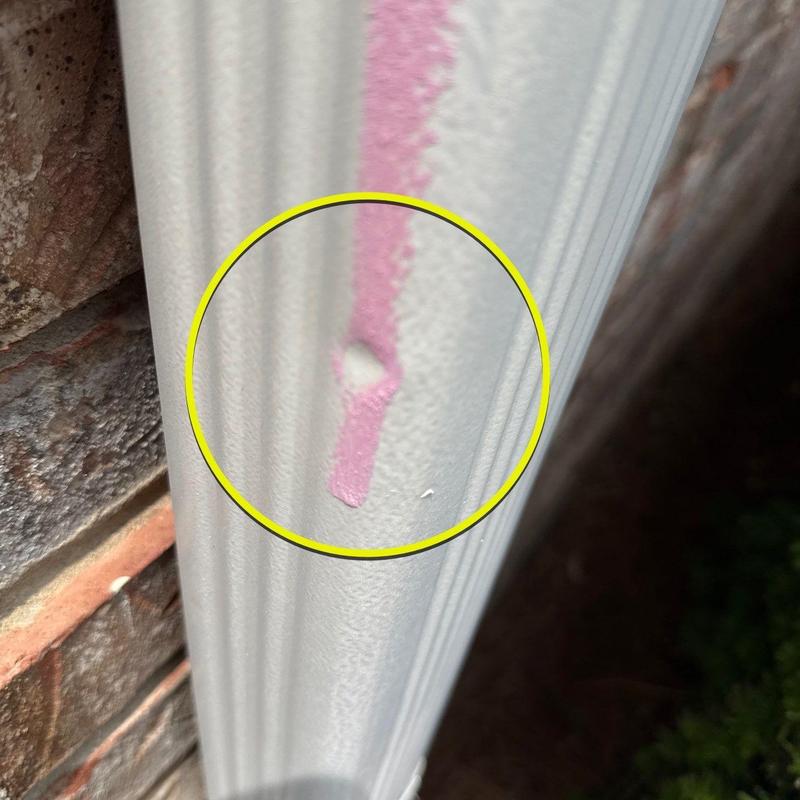 Vinyl siding hail damage marked with pink paint