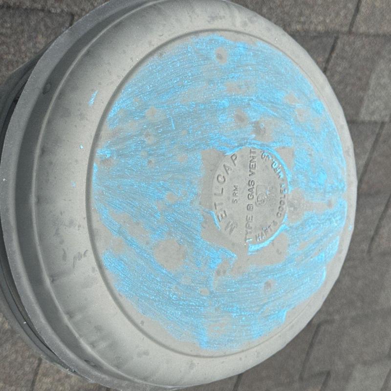 Gas vent metal cap on roof with weathering marks
